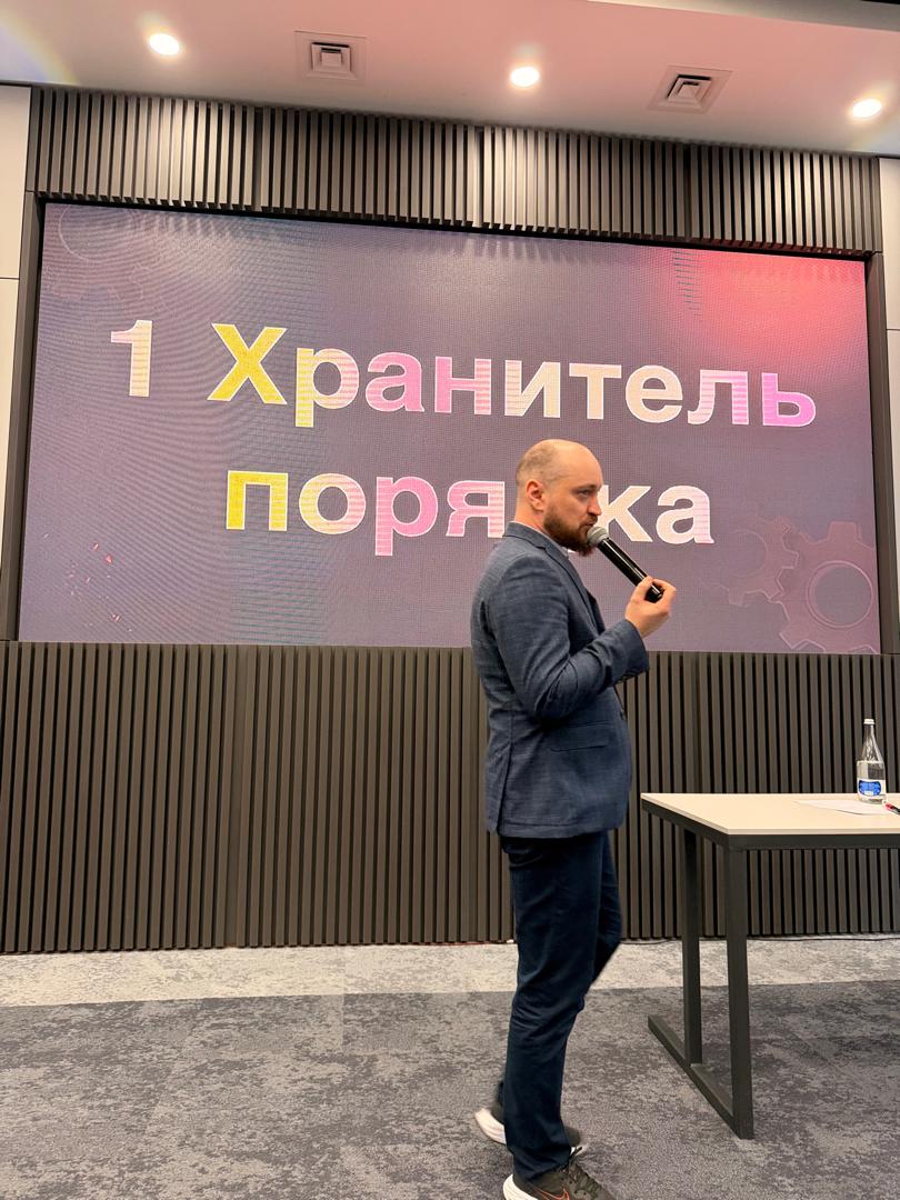 Алексей Беба у экрана со слайдом «Хранитель порядка»